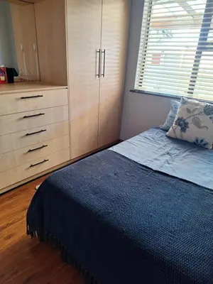 a bedroom with a bed and a large window at Kraaifontein Family Home in Cape Town