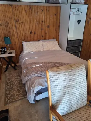 a bed in a room with a wooden wall at Kraaifontein Family Home in Cape Town