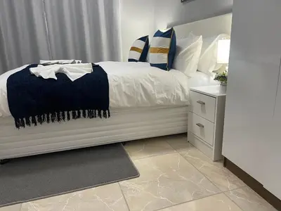 a bedroom with a bed with a blue and white blanket at Maita Guest in Cape Town