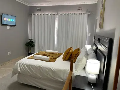 a bedroom with a large bed with white sheets and pillows at Maita Guest in Cape Town