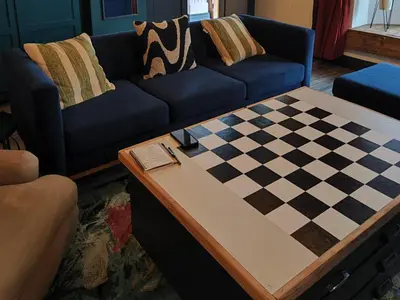 a living room with a couch and a chessboard on a table at Haus Michau in Strand
