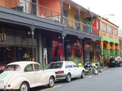 a white car parked in front of a building with motorcycles at Obs Centre Twin Peaks in Cape Town