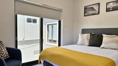 a bedroom with a bed and a large window at Obs Centre Twin Peaks in Cape Town