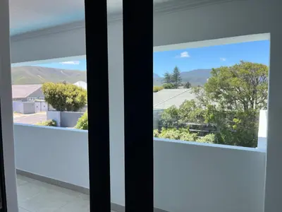 a window with a view of the mountains through it at The Cliff Villa Boutique Guesthouse in Hermanus