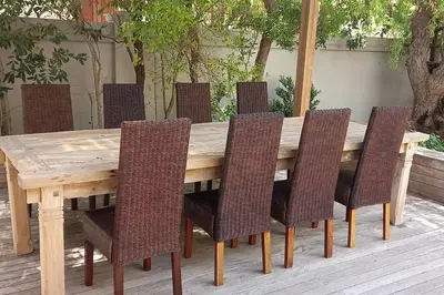 a wooden table with six chairs around it at Knight's House 6 sleeper in Hermanus