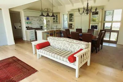 a living room with a couch and a dining room at Knight's House 6 sleeper in Hermanus