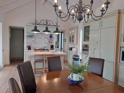 a kitchen and dining room with a table and chairs at Knight's House 6 sleeper in Hermanus