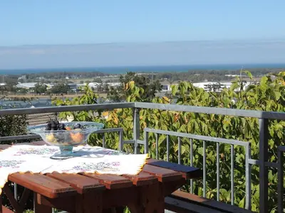 a wooden table with a bowl on top of a balcony at 8 on Lily Self catering in Cape Town