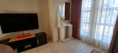 a living room with a flat screen tv next to a window at 8 on Lily Self catering in Cape Town