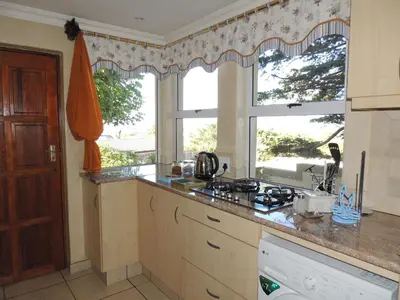 a kitchen with a counter top and a window at 8 on Lily Self catering in Cape Town