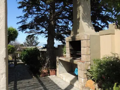 a stone fireplace with a tree in the background at 8 on Lily Self catering in Cape Town