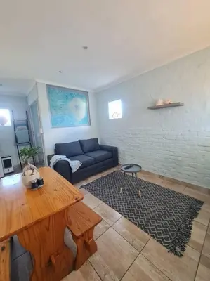 a living room with a couch and a table at H & E Sunset Paradise in Fisherhaven