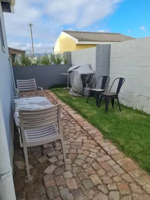 a patio with chairs and a table and a tent at H & E Sunset Paradise in Fisherhaven