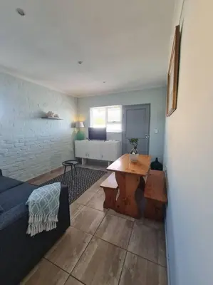 a living room with a couch and a table at H & E Sunset Paradise in Fisherhaven