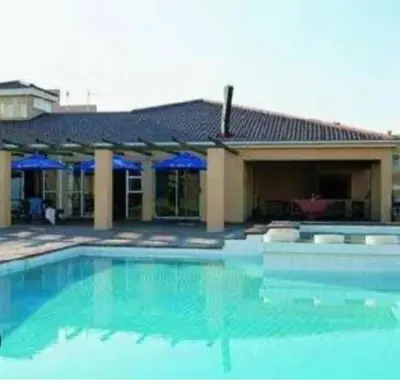 a large swimming pool in front of a building at The Hermanus holiday self catering beach club in Hermanus