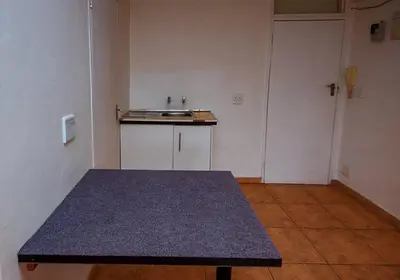 an empty kitchen with a table in a room at Montana Backpackers Cape Town in Cape Town