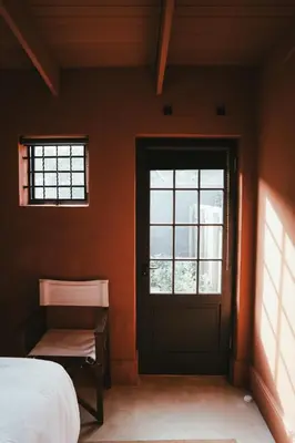 a bedroom with a door and a bed and a window at No 3 at The Barracks in Stellenbosch