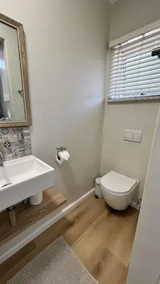 a bathroom with a sink and a toilet and a mirror at Paradysrus in Stellenbosch