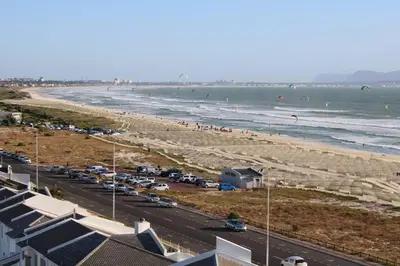a view of a beach with people in the water at Jacuzzi with 270 views right on beach in Cape Town