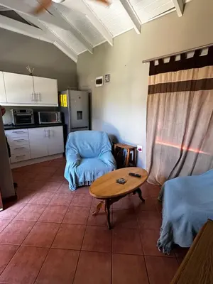 a living room with a table and a kitchen at Jacob's Rest in Cape Town