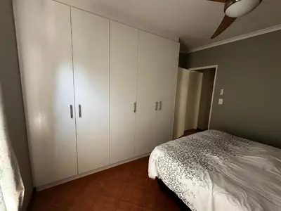 a bedroom with white cabinets and a bed at Jacob's Rest in Cape Town