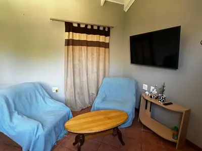 a living room with a couch and a table and a tv at Jacob's Rest in Cape Town