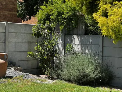 a fence in a yard with some bushes at Jacob's Rest in Cape Town