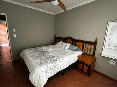 a bedroom with a bed and a ceiling fan at Jacob's Rest in Cape Town