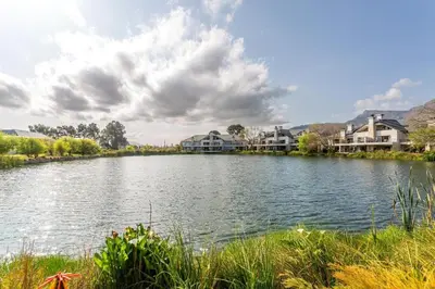 a large lake with houses in the background at Luxury Lodge 4F Pearl Valley Golf Estate in Simondium