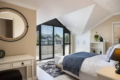 a bedroom with a large bed and a mirror at Luxury Lodge 4F Pearl Valley Golf Estate in Simondium