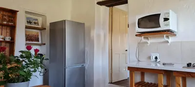 a kitchen with a refrigerator and a microwave on the wall at Whipstock Guest Farm in McGregor