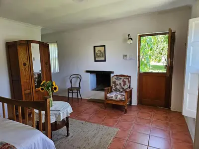 a bedroom with a bed and a chair and a fireplace at Whipstock Guest Farm in McGregor