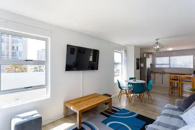 a living room with a couch and a table at Ocean View B104 by CTHA in Bloubergstrand
