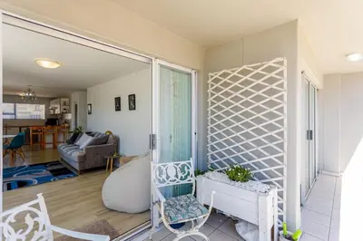 a living room with a window and a couch at Ocean View B104 by CTHA in Bloubergstrand