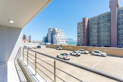 a balcony with cars parked in a parking lot at Ocean View B104 by CTHA in Bloubergstrand