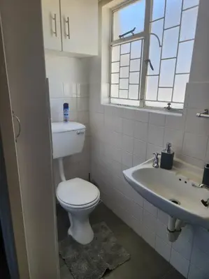 a white bathroom with a toilet and a sink at HartebeesDen in Worcester