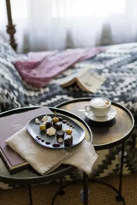 a plate of chocolates on a table with a cup of coffee at The Thatch House Boutique Hotel, Hermanus in Hermanus