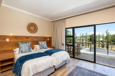 a bedroom with two beds and a balcony at Pearl Valley Golf Estate Lodge 1E in Simondium