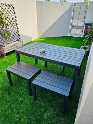 a picnic table and two benches sitting on the grass at Blouberg Rise Cottage in Cape Town