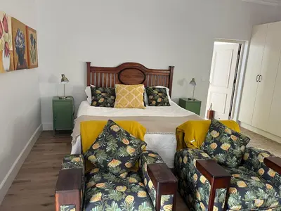 a bedroom with a bed and two couches at On Musson in Hermanus