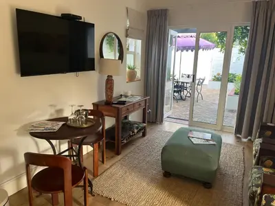 a living room with a table and a television on the wall at On Musson in Hermanus