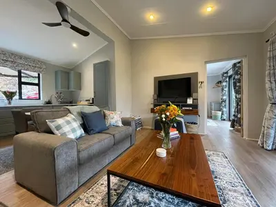 a living room with a couch and a table at Stonehedge Cottages in Franschhoek
