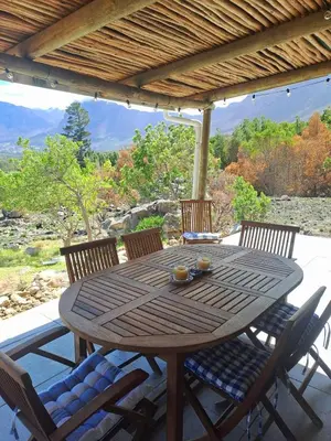 a wooden table and chairs on a patio at Stonehedge Cottages in Franschhoek