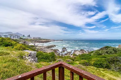 a view of the ocean from a wooden deck at Oak Terrace 28 in Hermanus