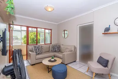 a living room with a couch and a table at Oak Terrace 28 in Hermanus