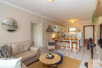 a living room with a couch and a table at Oak Terrace 28 in Hermanus