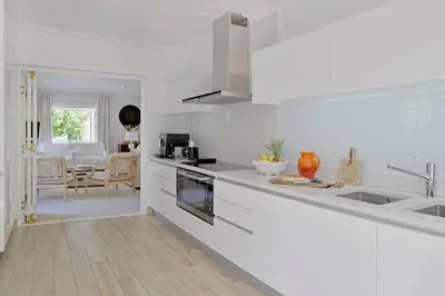 a white kitchen with a sink and a counter at Farm Lorraine The Loft Cottage in Franschhoek