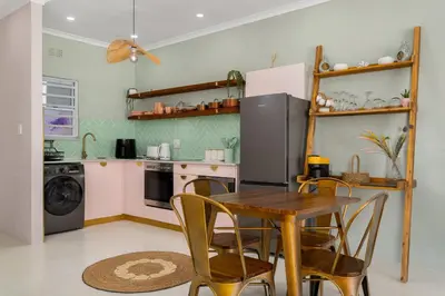 a kitchen with a table and chairs and a refrigerator at 323 Leisure Bay in Cape Town