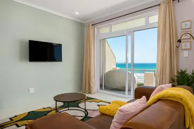 a living room with a couch and a large window at 323 Leisure Bay in Cape Town