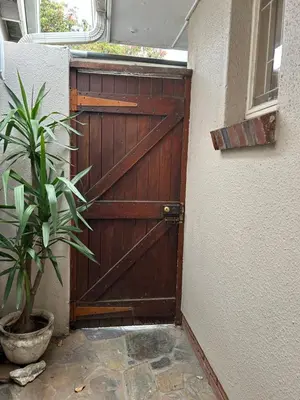 a wooden garage door with a potted plant next to it at La Casetta, Garden Retreat in Cape Town